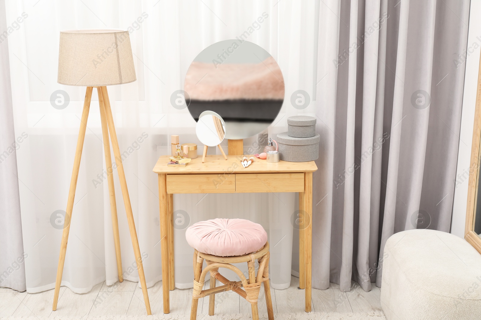 Photo of Mirror, dressing table, lamp and stool near window indoors. Interior design