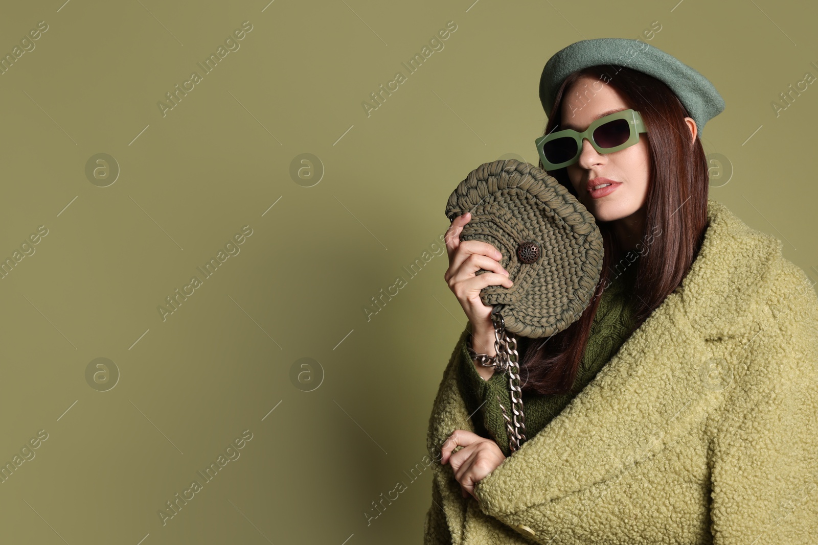 Photo of Young woman with stylish accessories on olive background, space for text