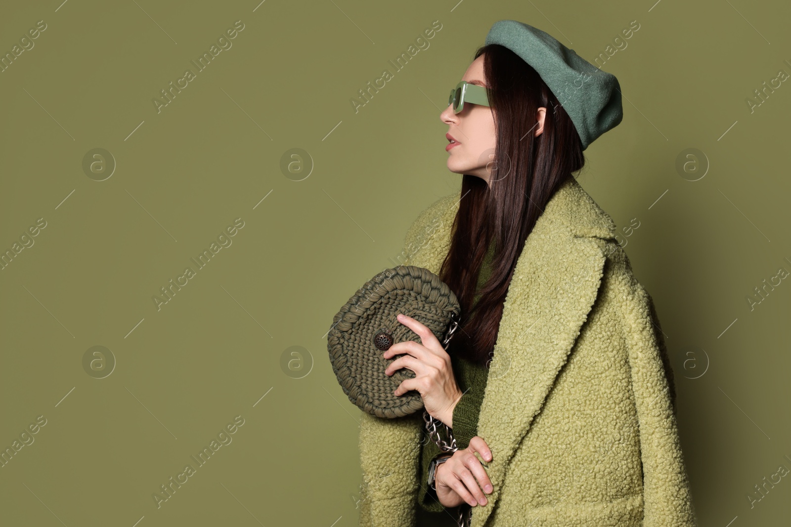 Photo of Young woman with stylish accessories on olive background, space for text