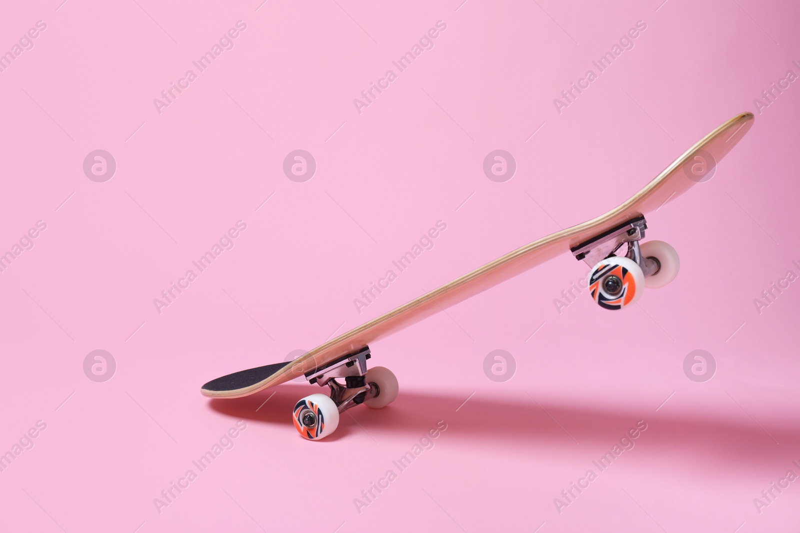 Photo of One skateboard on pink background. Sports equipment