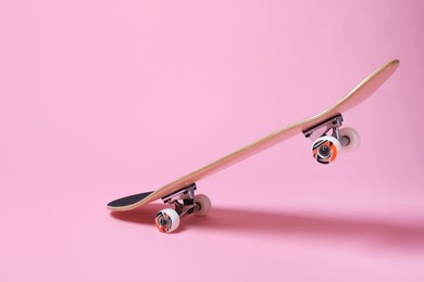 Photo of One skateboard on pink background. Sports equipment