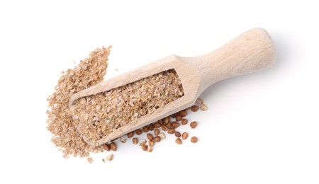 Photo of Buckwheat bran in wooden scoop and grains isolated on white, top view