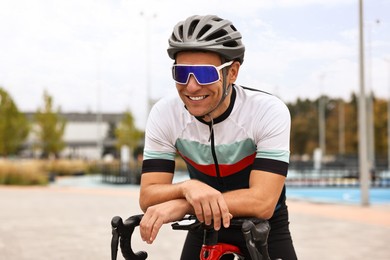 Photo of Athletic man with helmet and bicycle outdoors