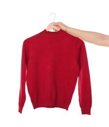 Photo of Woman holding hanger with bright sweater on white background, closeup