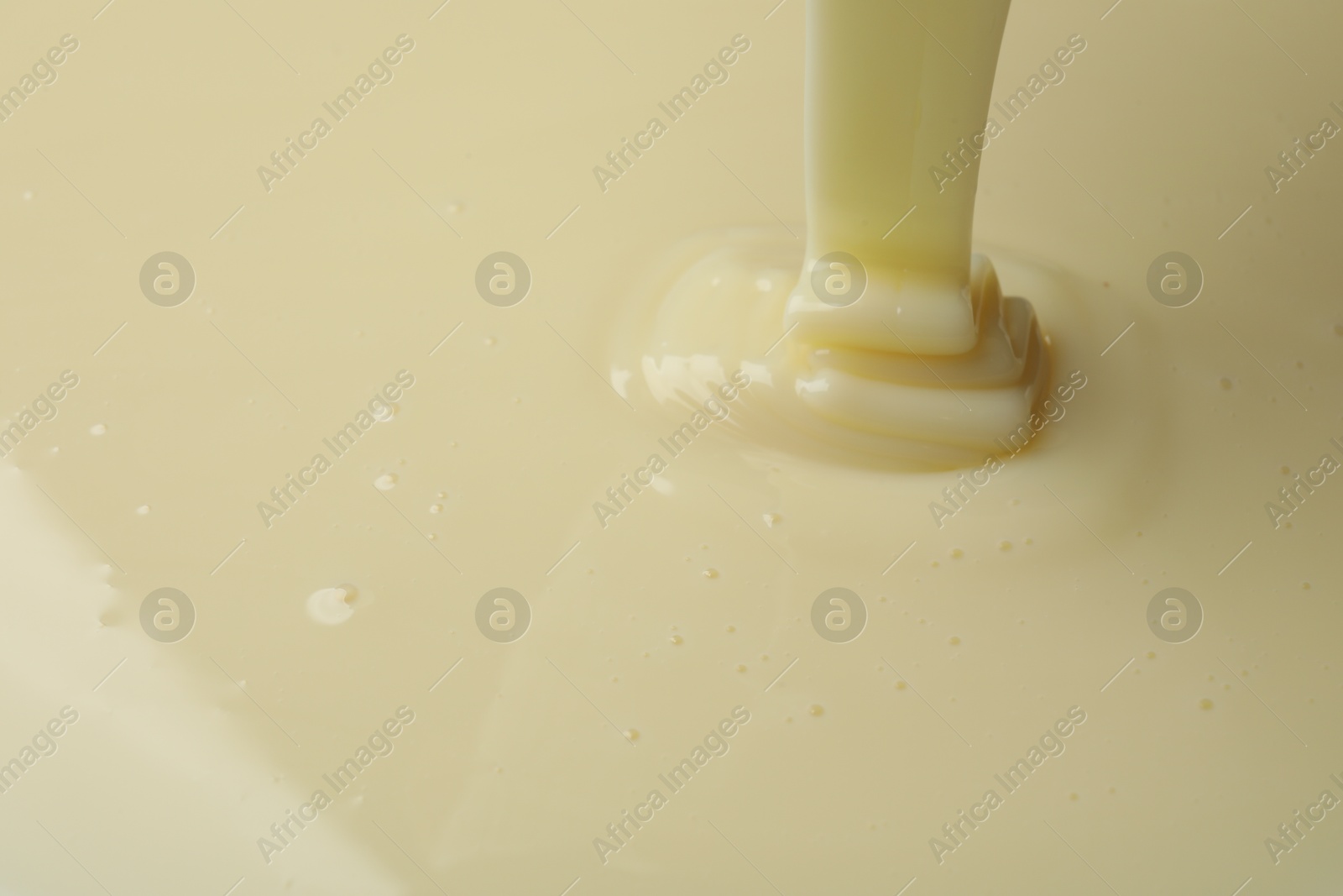 Photo of Pouring delicious condensed milk as background, closeup