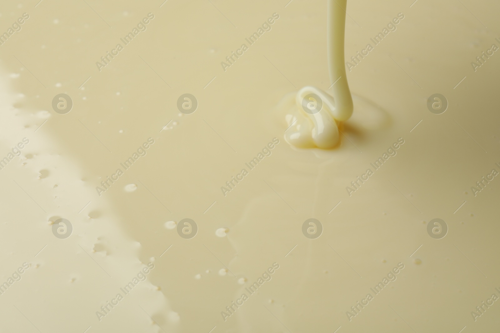 Photo of Pouring delicious condensed milk as background, closeup