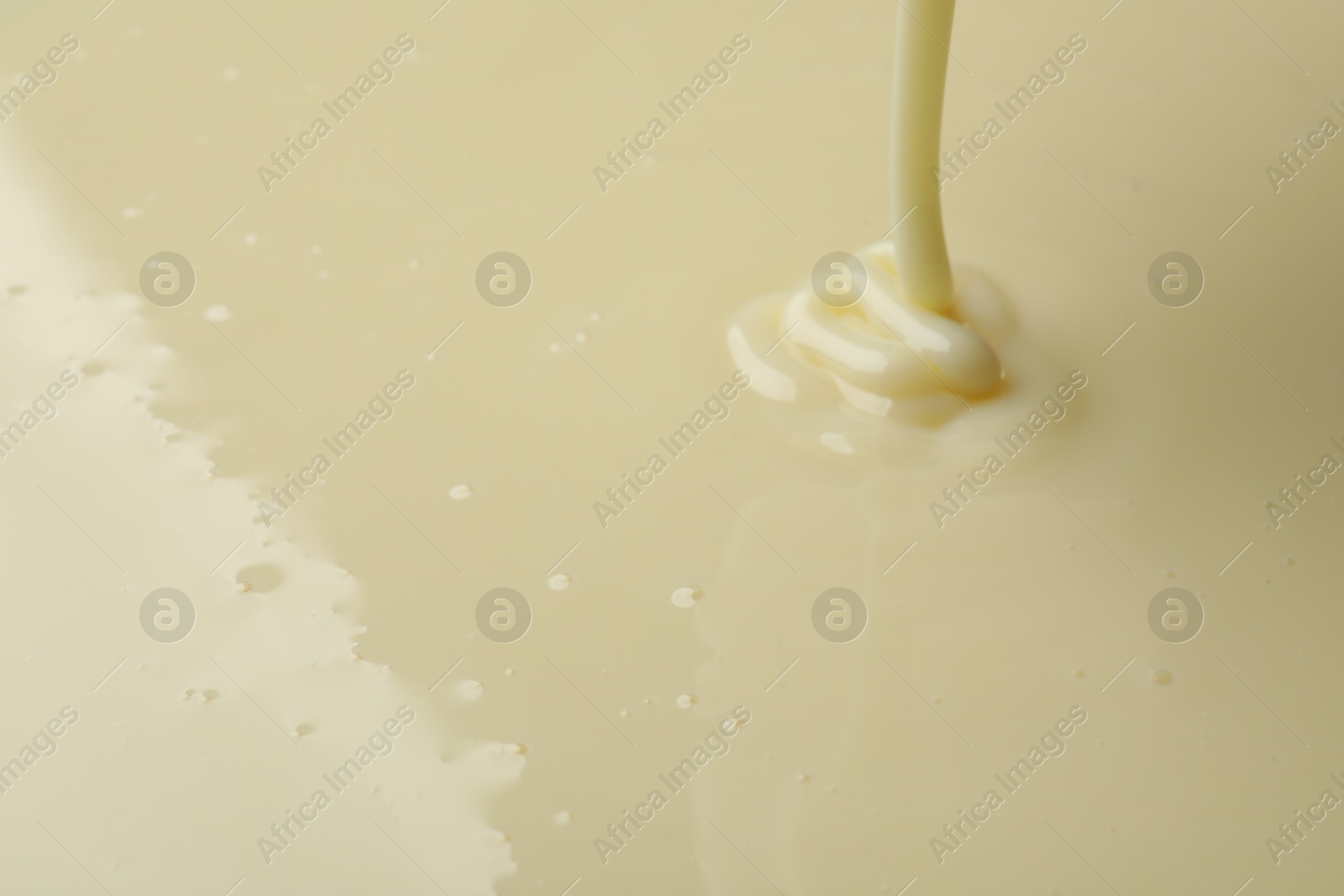 Photo of Pouring delicious condensed milk as background, closeup