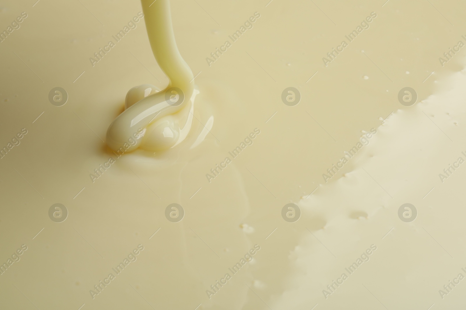 Photo of Pouring delicious condensed milk as background, closeup