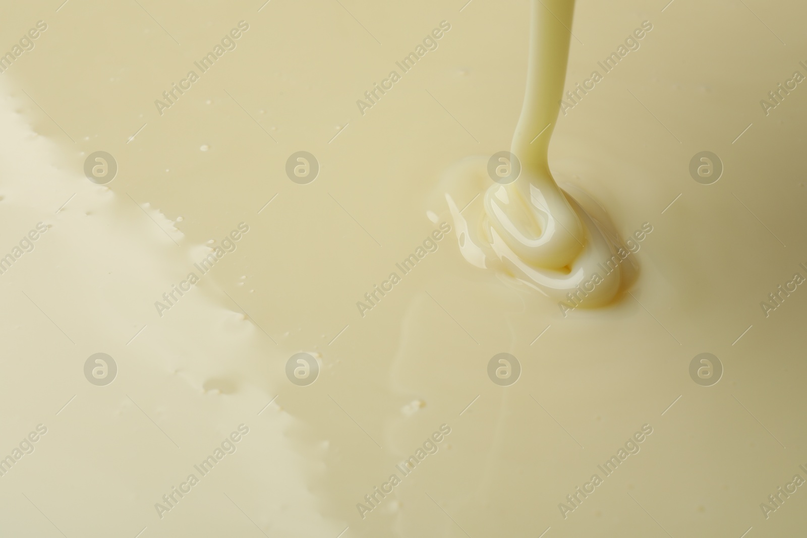 Photo of Pouring delicious condensed milk as background, closeup