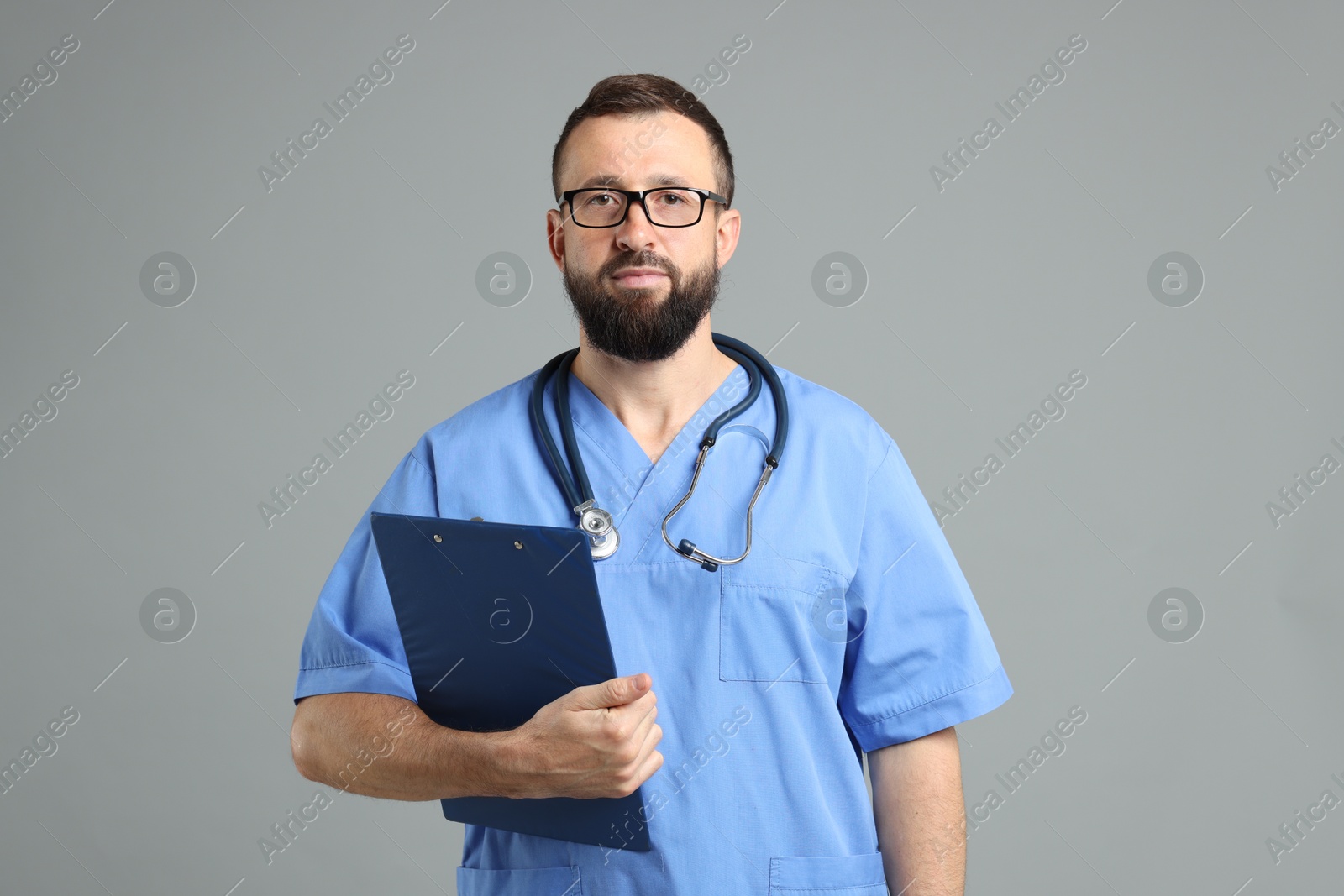 Photo of Doctor with clipboard and stethoscope on grey background