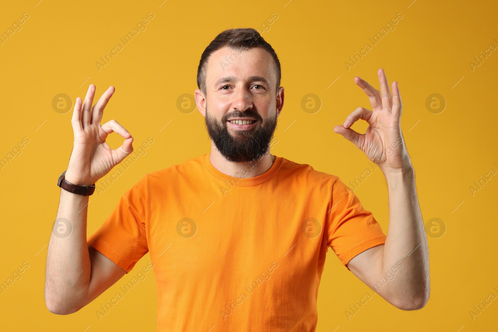 Photo of Man showing okay gesture on orange background