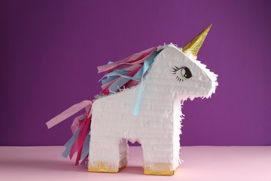 Photo of Bright pinata in shape of unicorn on color background