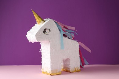 Photo of Bright pinata in shape of unicorn on color background