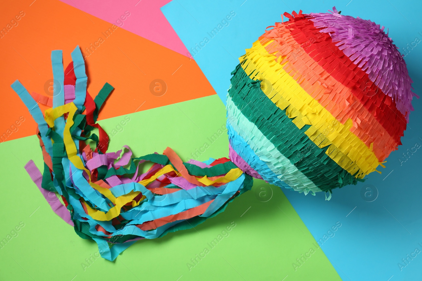 Photo of Colorful pinata on color background, top view