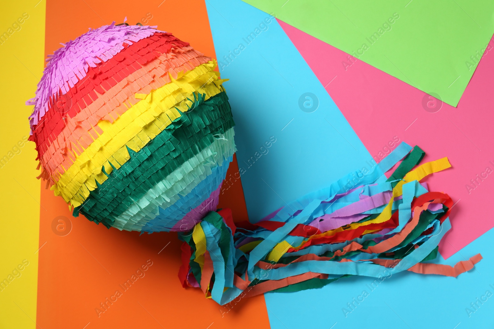 Photo of Colorful pinata on color background, top view