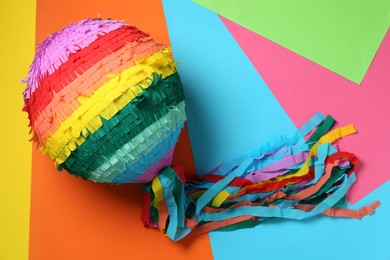 Photo of Colorful pinata on color background, top view