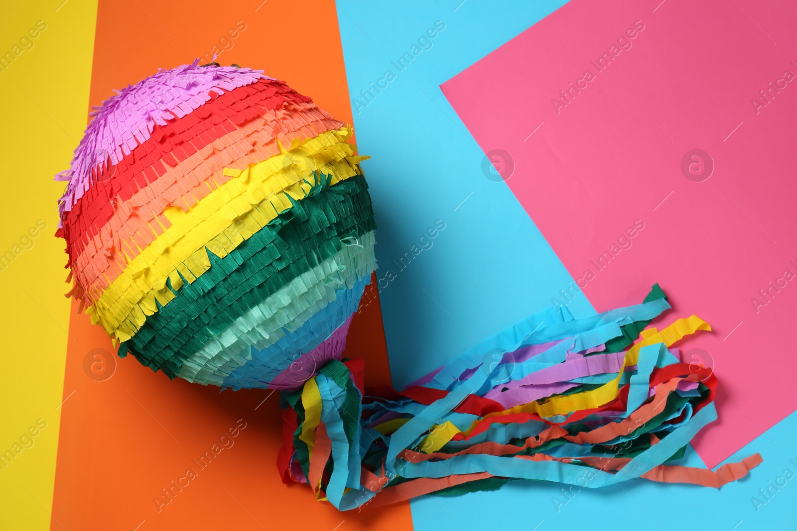 Photo of Colorful pinata on color background, top view