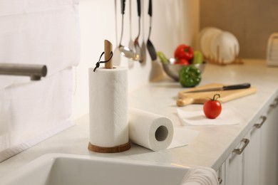 Rolls of paper towels on white marble countertop near sink in kitchen