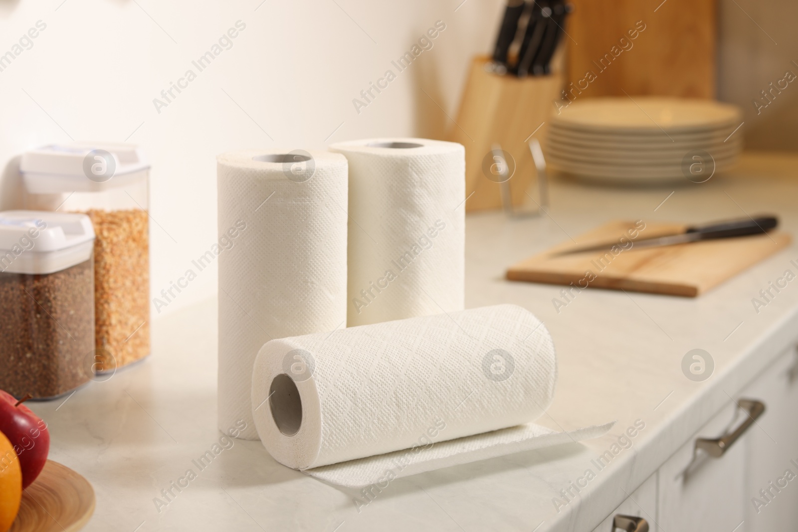 Photo of Rolls of paper towels on white marble countertop in kitchen