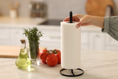 Woman using paper towels at white marble table in kitchen, closeup