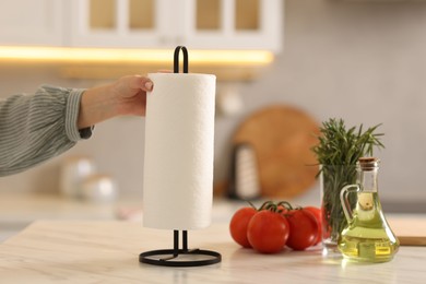 Photo of Woman using paper towels at white marble table in kitchen, closeup