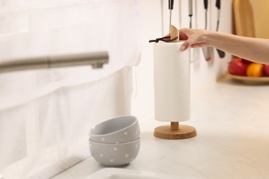 Photo of Woman using paper towels in kitchen, closeup