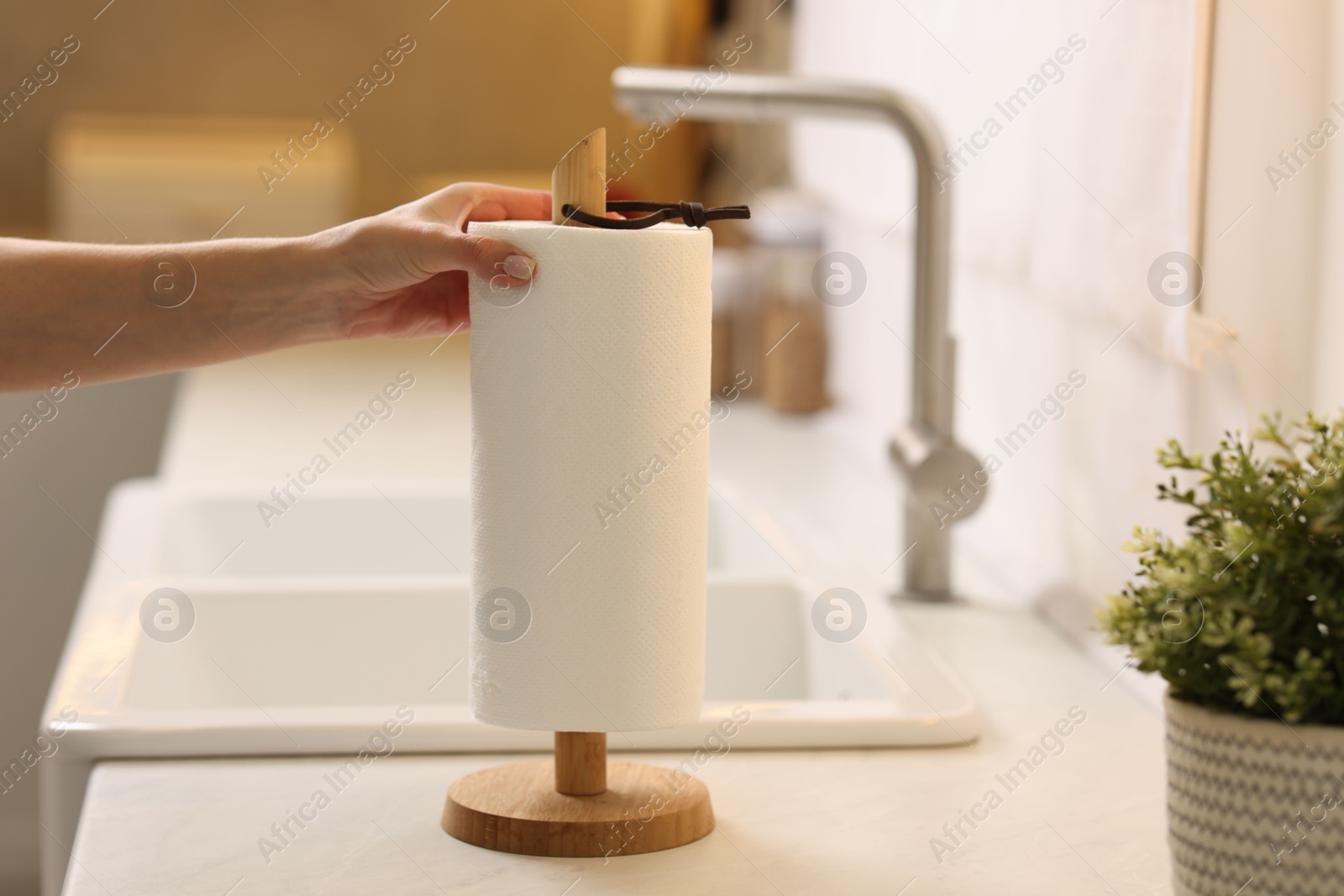 Photo of Woman using paper towels in kitchen, closeup