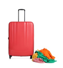 Photo of Red suitcase and messy pile of clothes isolated on white