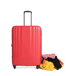 Photo of Red suitcase and messy pile of clothes isolated on white