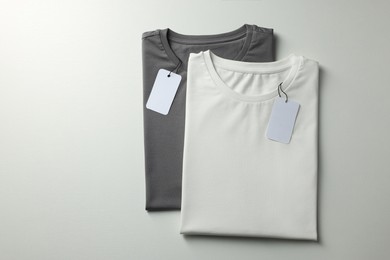 Photo of Different blank t-shirts on white background, top view. Mockup for design