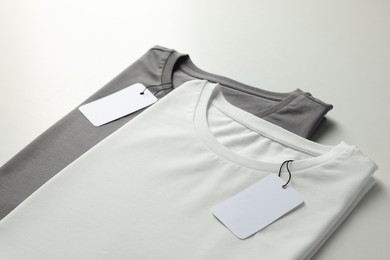 Photo of Different blank t-shirts on white background, closeup. Mockup for design