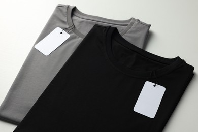 Photo of Different blank t-shirts on white background, closeup. Mockup for design