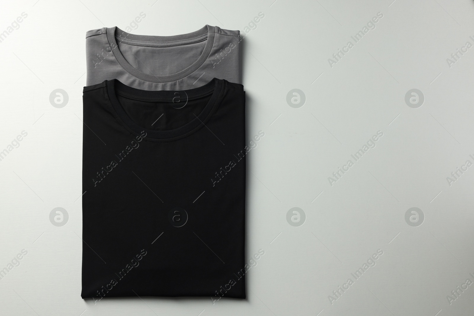 Photo of Different blank t-shirts on white background, top view. Mockup for design