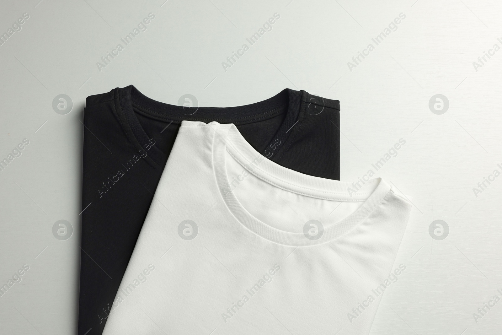 Photo of Different blank t-shirts on white background, top view. Mockup for design