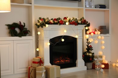 Photo of Stylish fireplace with Christmas decor and presents in cozy room