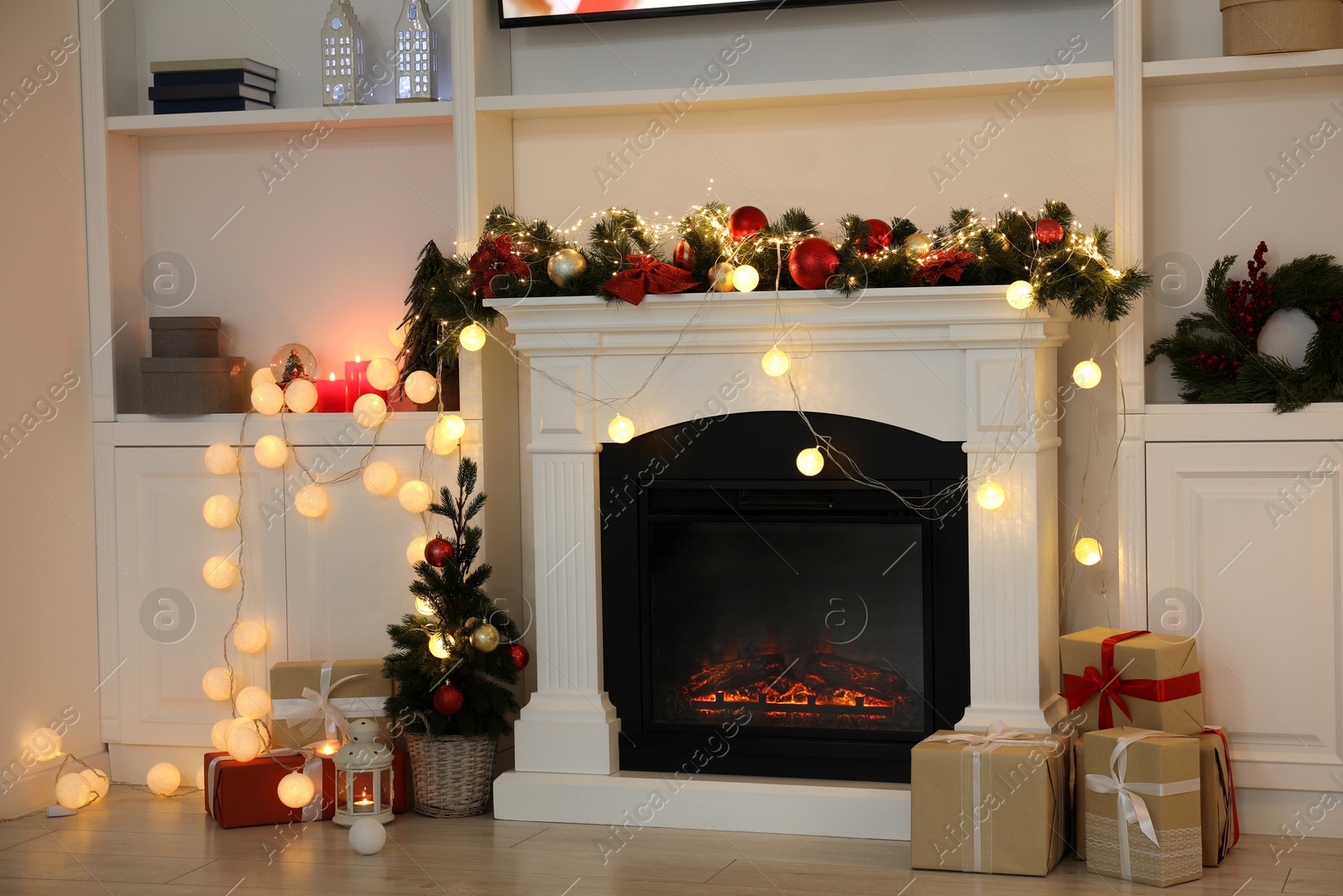 Photo of Stylish fireplace with Christmas decor and presents in cozy room