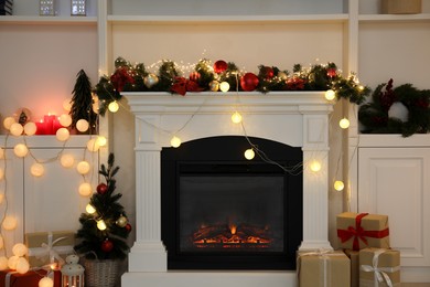 Photo of Stylish fireplace with Christmas decor and presents in cozy room