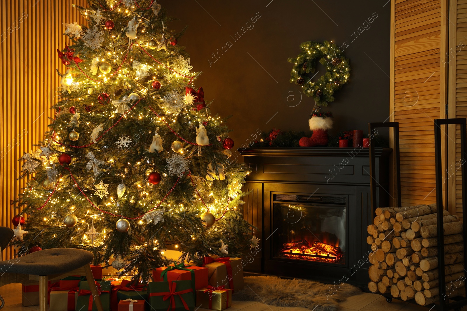 Photo of Christmas tree with festive decor, presents and fireplace in cozy room