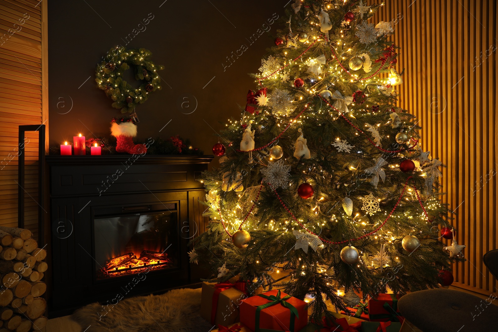 Photo of Christmas tree with festive decor, presents and fireplace in cozy room