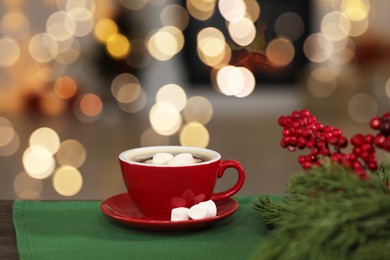 Photo of Tasty cocoa with marshmallows in cup and decor on table. Christmas drink