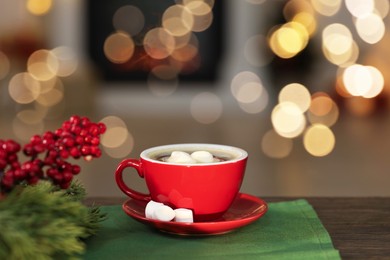 Photo of Tasty cocoa with marshmallows in cup and decor on wooden table. Christmas drink