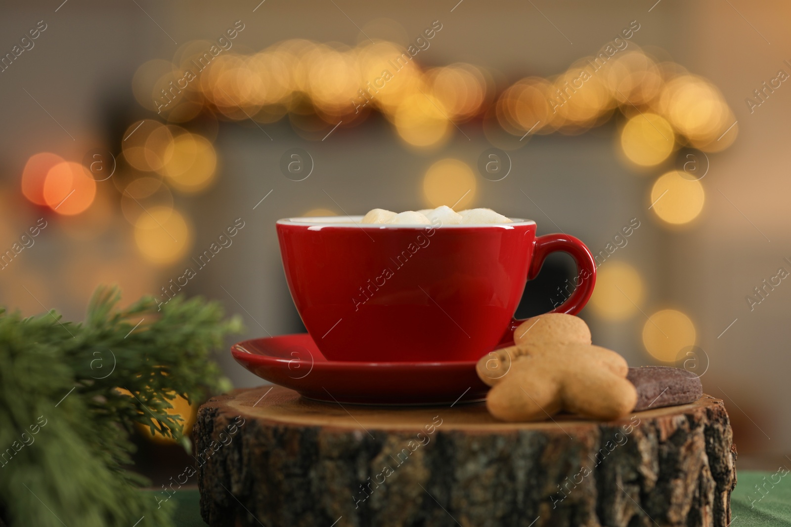 Photo of Tasty cocoa with marshmallows in cup, cookies and decor on table against blurred Christmas lights, closeup. Bokeh effect