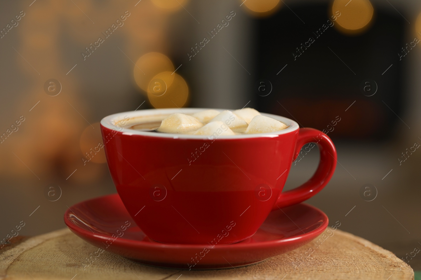 Photo of Tasty cocoa with marshmallows in cup on stump, closeup. Christmas drink