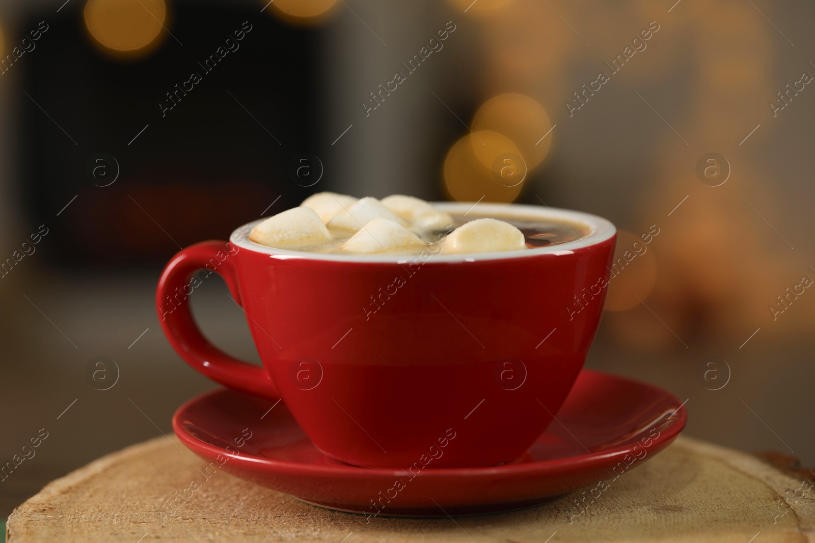 Photo of Tasty cocoa with marshmallows in cup on stump, closeup. Christmas drink