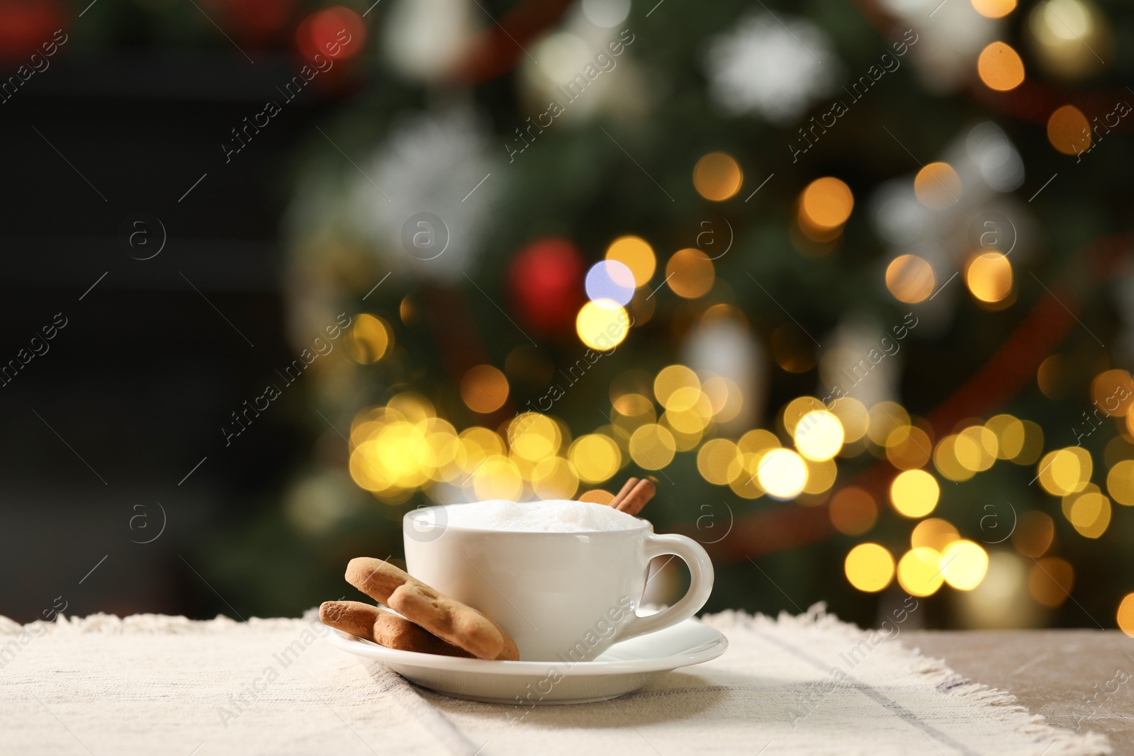 Photo of Aromatic coffee in cup and tasty cookies on table against blurred Christmas lights. Bokeh effect