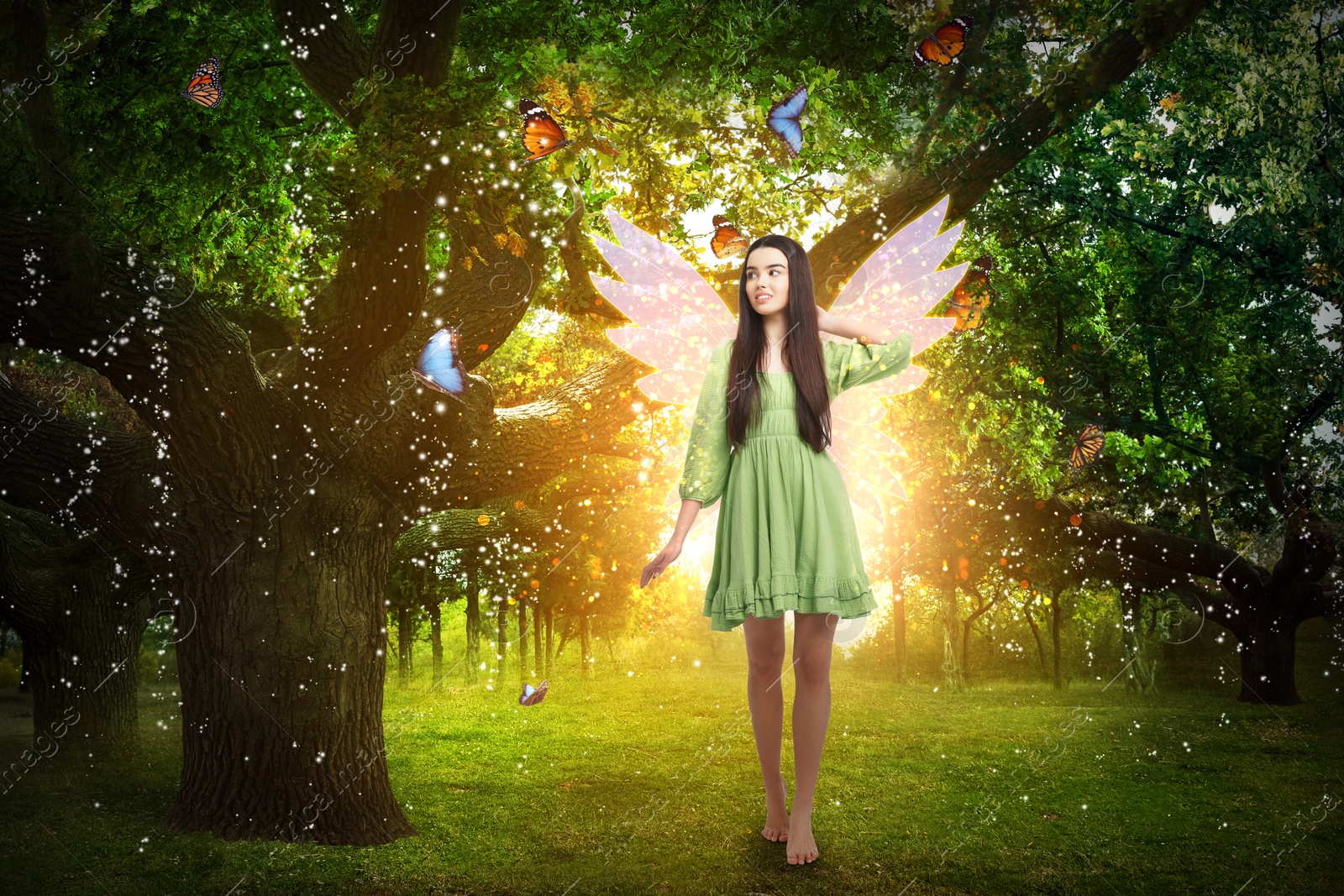 Image of Enchanting fairy surrounded by butterflies walking among trees. Mesmerizing girl with ethereal wings in charmed forest