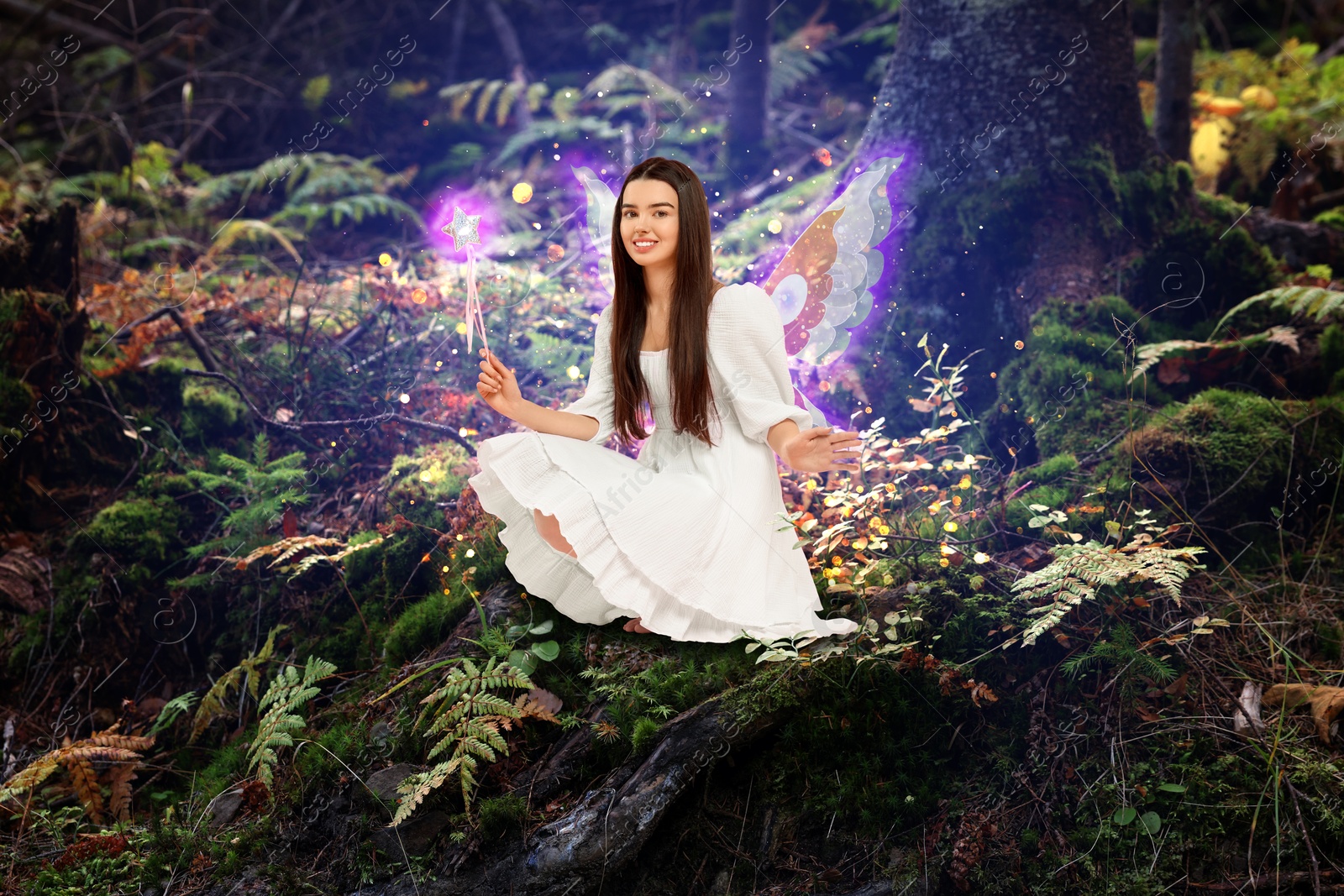 Image of Charming fairy with magic wand in forest. Mesmerizing girl with ethereal wings