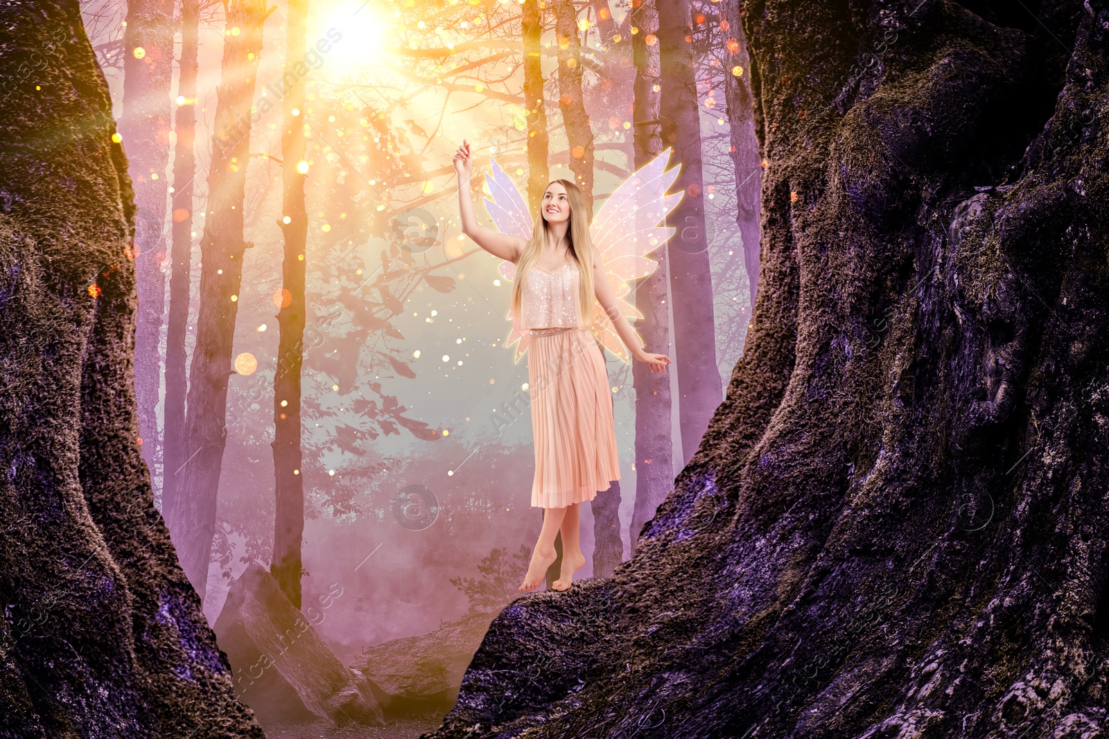 Image of Enchanting fairy touching magic light among trees. Mesmerizing girl with ethereal wings in charmed forest