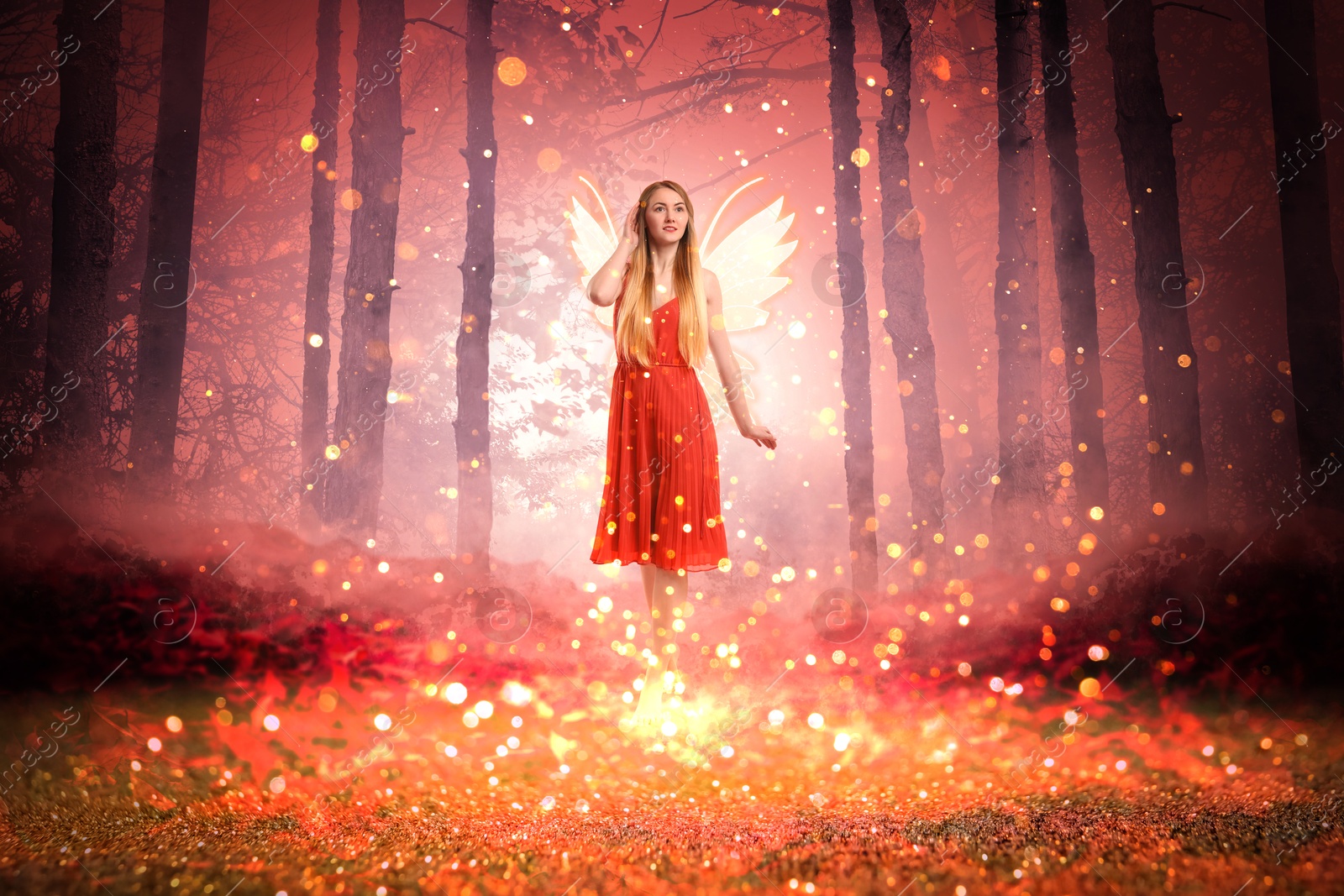 Image of Enchanting fairy surrounded by magic lights among trees. Mesmerizing girl with ethereal wings in charmed forest