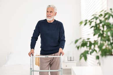 Photo of Senior man with walking frame in hospital ward